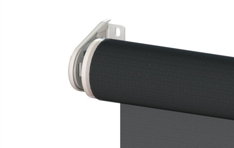 Close-up of a roller blind mechanism with a black fabric shade mounted to a white bracket on a wall